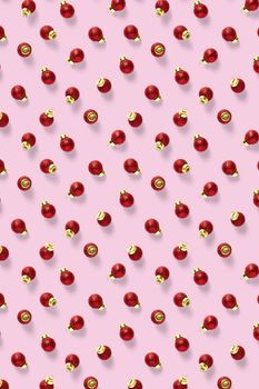 Christmas red decorations on pink background. Christmas ornaments composition for background. Flat lay background madefrome red ornaments decorations