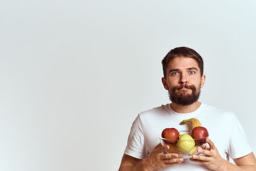 man with fresh fruit in a glass cup gesturing with hands vitamins health energy model bushy beard mustache. High quality photo