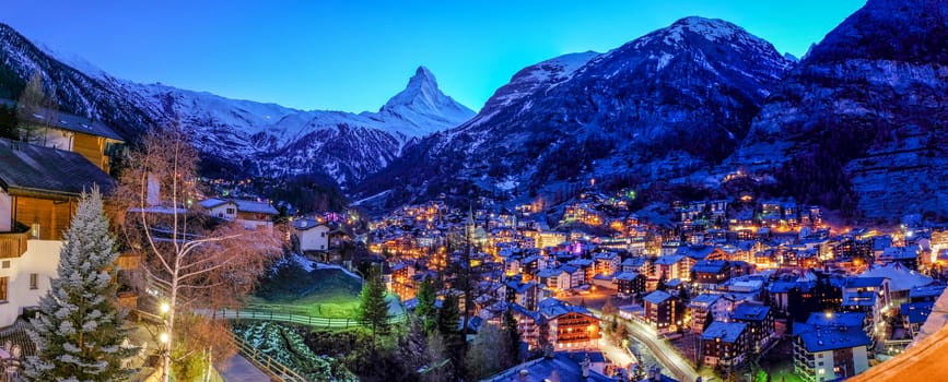 Beautiful view of old village in twilight time with Matterhorn peak background in Zermatt, Switzerland.