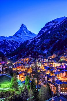 Beautiful view of old village in twilight time with Matterhorn peak background in Zermatt, Switzerland.
