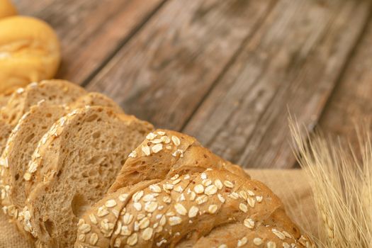 breads sliced and wheatgrass on the sack with a wooden table