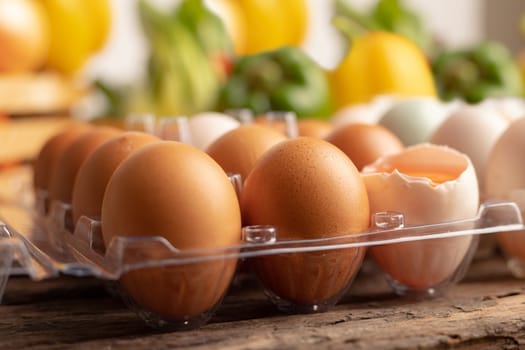 Close up eggs of chicken placed on a wooden table with various vegetables in wood box. Select focus shallow depth of field and blurred background.