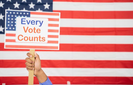 Hands Holding Every Vote counts sign board with US Flag as Background with copy space - Concept of voter rights and US election