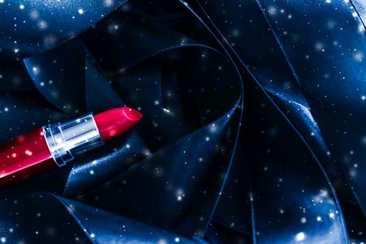 Red lipstick on blue silk and shiny glitter background, luxury make-up and beauty cosmetics