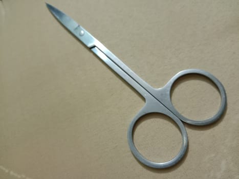 silver colored scissors closeup on golden background