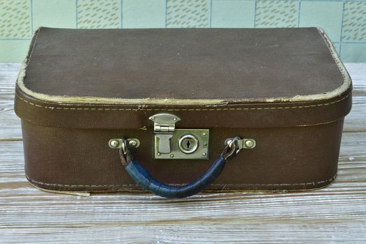  old suitcase lies on a shabby wooden table