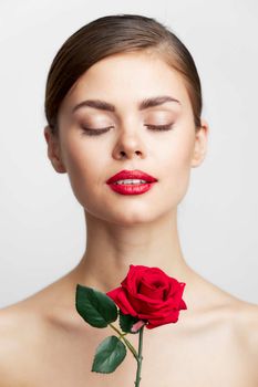 woman with bare shoulders Closed eyes charm rose in hands lipstick background