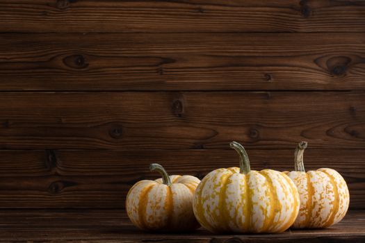 Decorative striped Gourds or Pumpkins on Wood table background