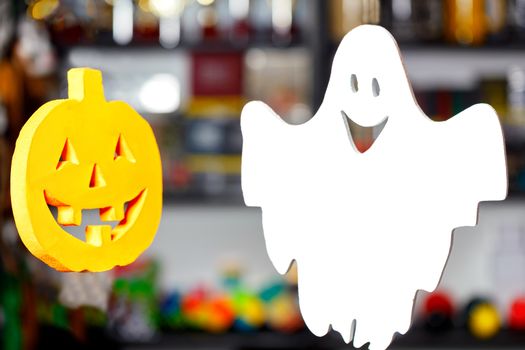 Halloween, two soaring merry ghosts in the form of a pumpkin head and a white ghost on a blurred background.