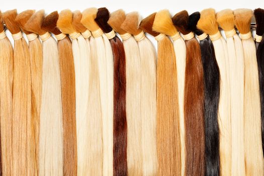 Bundles of natural shiny healthy human hair in wheat shades, chocolate color, brown. Women's hair care, style and beauty concept.