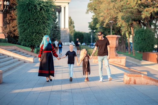 Unusual Family of four people are walking hand in hand in the park. Modern trend, unusual black punk style