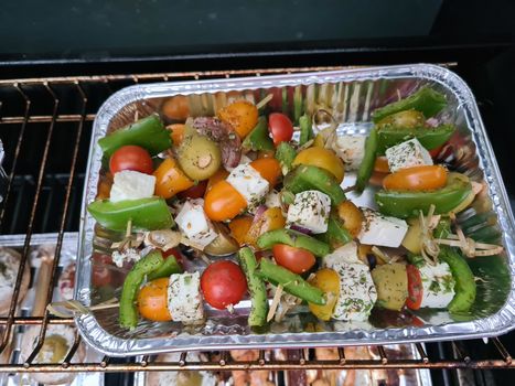 Grilled skewers with mixed vegetables served on a wooden cutting board with a vegan herb dip