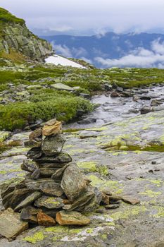 Stacked stones by the Hydnefossen waterfall and Hydna river on Veslehødn Veslehorn mountain in Hemsedal, Norway.