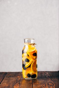 Bottle of Infused Water with Sliced Raw Orange and Fresh Blackberry.