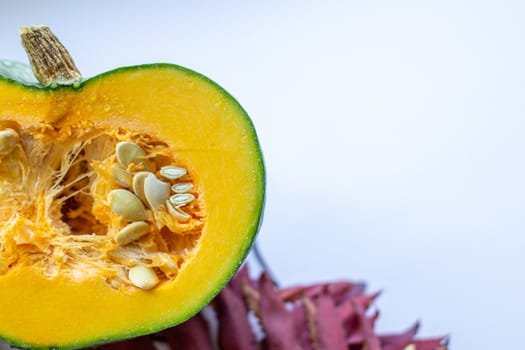 Cut ripe, yellow pumpkin on a wooden background with autumn leaves. Autumn background