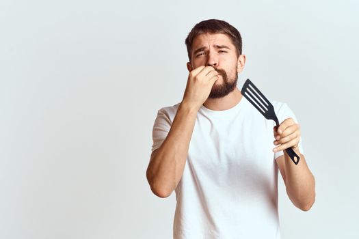 man with cooking shovel and white t-shirt close-up cropped view emotion gesturing with hand. High quality photo