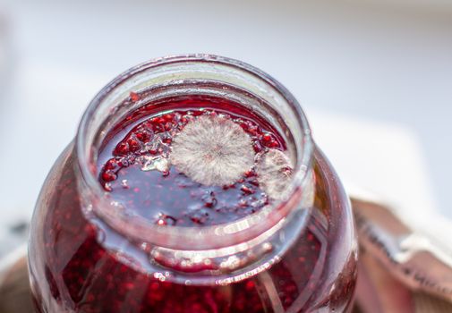 Mold in a jar of raspberry jam. Hazardous to health. Mold. High quality photo