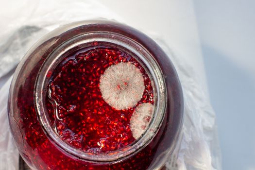 Mold in a jar of raspberry jam. Hazardous to health. Mold. High quality photo