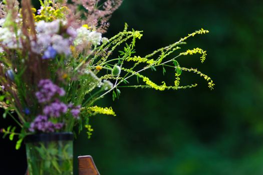 Bouquet of wild flowers in vase in a garden.Closeup view.