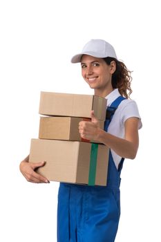 Portrait of happy smiling delivery woman with stack of boxes showing thumb up isolated on white background