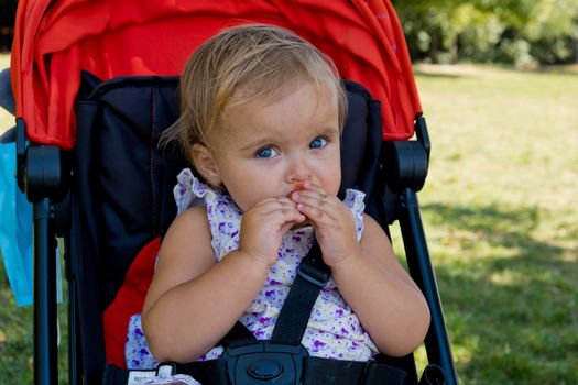 Portrait of cute baby girl eat red watermelon. Close-up. Outdoor.