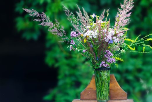 Bouquet of wild flowers in vase in a garden. Soft focus, nice bokeh