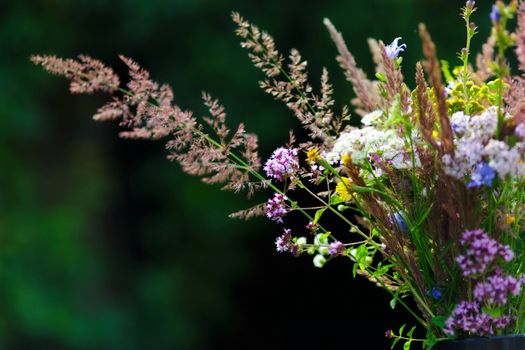 Bouquet of wild flowers in vase in a garden.Closeup view.