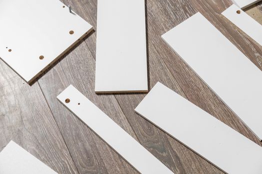 White wooden parts for self-assembly of furniture.