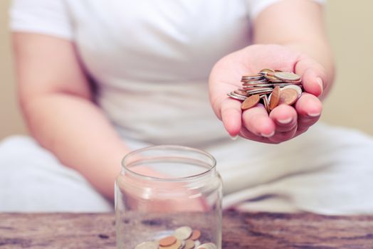 Save money and account banking for finance concept, Hand with coin bottle blurred background