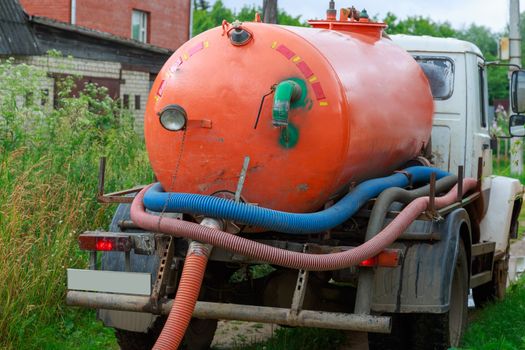 A Sewage truck working in village environment.