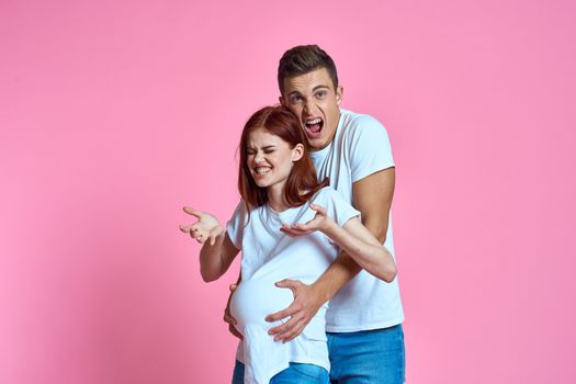 pregnant mom and happy father on pink background Young family waiting for baby. High quality photo