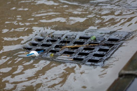 Dirty rainwater drains into a road rain storm.