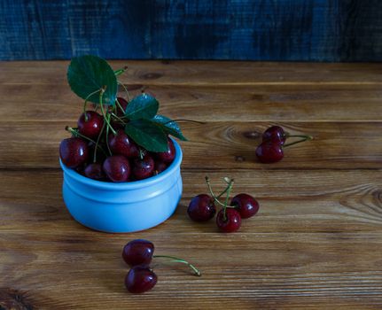 Fresh cherry on plate on wooden blue background. fresh ripe cherries. sweet cherries.