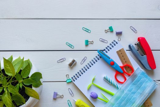 Back to school concept school office supplies on a white wooden background copy space. Education during self isolation on quarantine. Coronavirus concept.