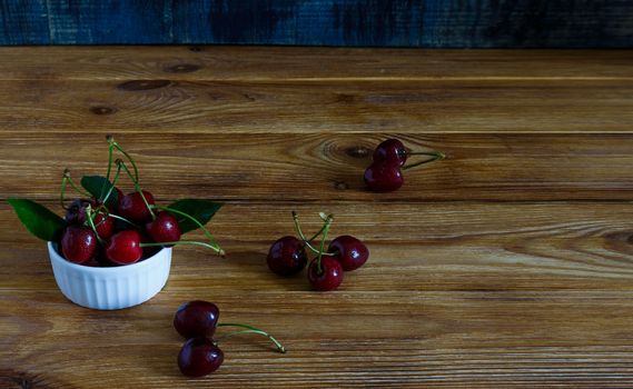 Fresh cherry on plate on wooden blue background. fresh ripe cherries. sweet cherries.