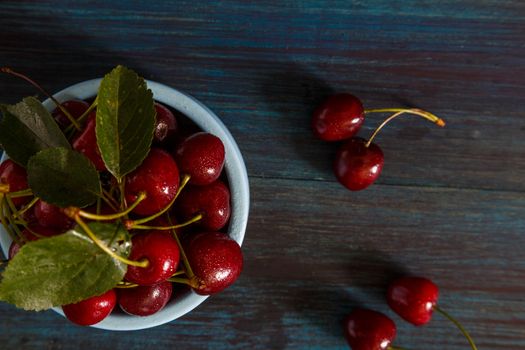 Fresh cherry on plate on wooden blue background. fresh ripe cherries. sweet cherries.