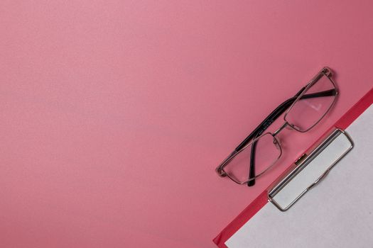 Eyeglasses and paper tablet on the table. High quality photo