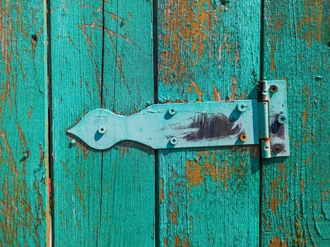 Old rusty door hinge on a wooden fence door