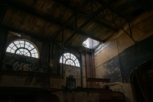 Two Large Windows in an Abandoned Theatre Letting Light Shine Into the Room