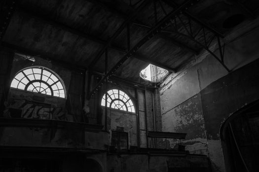 Two Large Windows in an Abandoned Theatre Letting Light Shine Into the Room