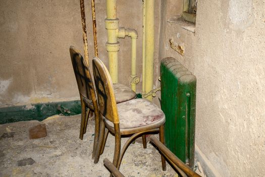 Two Chairs Covered in Dust and Debris inside an Old and Abandoned Building