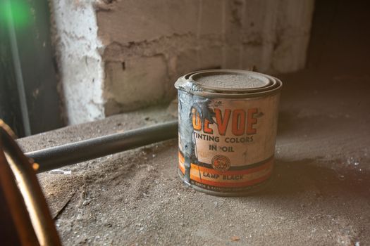 NEWARK, NEW JERSEY - JULY 17th, 2020: An Antique Can of Devoe Tinting Colors in Oil Sits Forgotten in the Abandoned Proctor's Palace Theatre in Newark New Jersey. Some of the Paint Has Spilled Onto the Side of the Can.