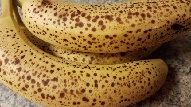 ripe banana fruit with spots on peel on counter