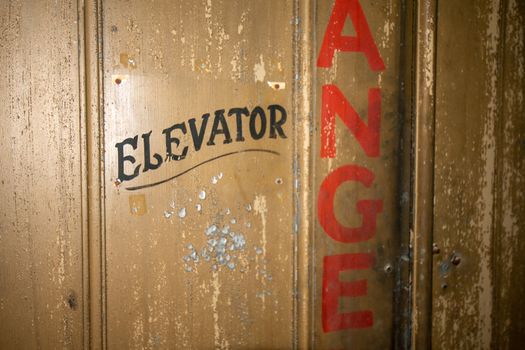 An Old Fashioned Door With Text That Says Elevator on It