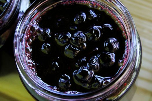 Homemade chokeberry jam. The process of filling jars in a homely way. Zavidovici, Bosnia and Herzegovina.