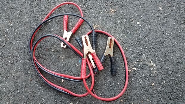 red and black metal jumper cables on ground