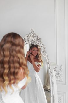 Close-up of a bride looking in a mirror before wedding ceremony.