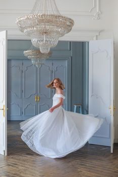 The bride in a beautiful white wedding dress is spinning showing the charm of her outfit.