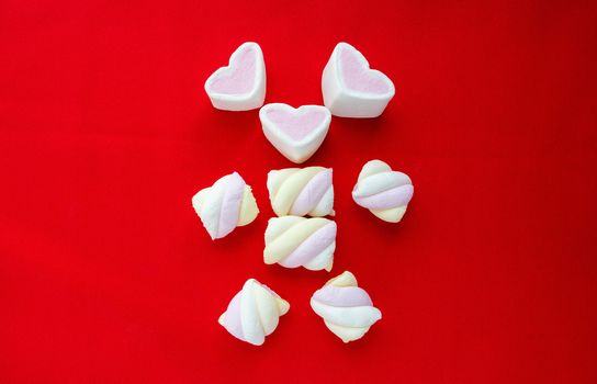 Colorful marshmallow candy isolated on red background.
