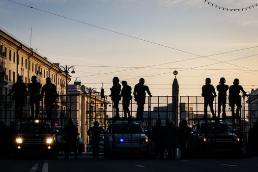 Riot police blocking the road for protesters. The army is blocking the city. Silhouettes of soldiers